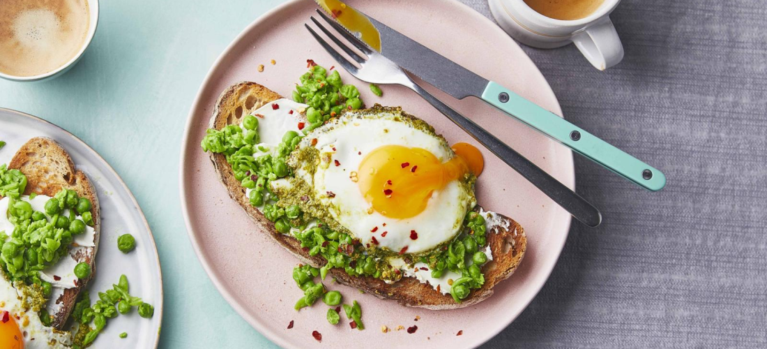 Si të përgatisni lehtësisht një vakt të shpejtë dhe të shëndetshëm me vezë me pesto dhe bizele të shtypura mbi bukë të thekur